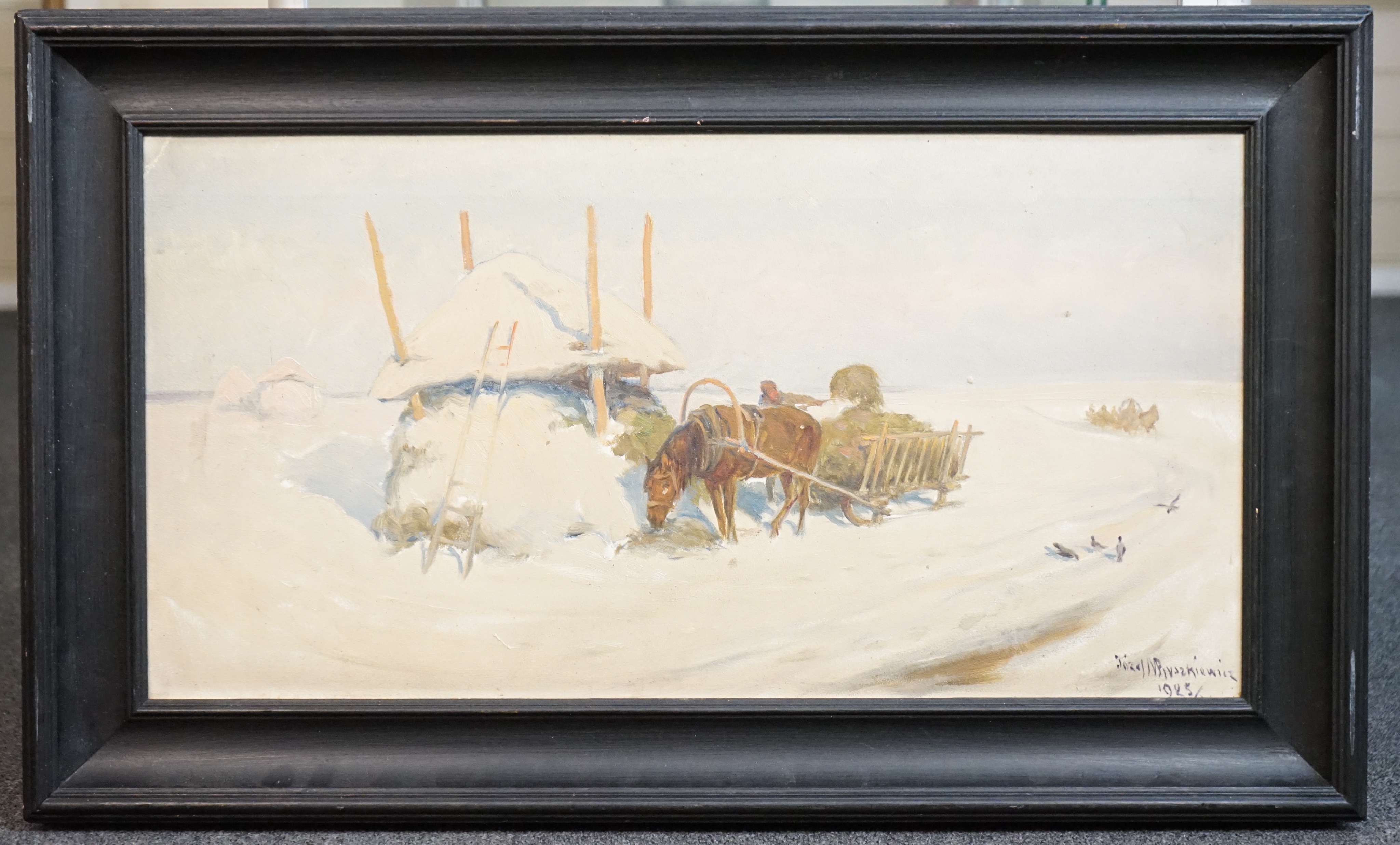 Józef Ryszkiewicz (Polish, 1856-1925), Winter landscape with figure loading a haycart, a troika beyond, oil on artist board, 34 x 66cm